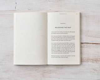 An open book resting on a wooden table.