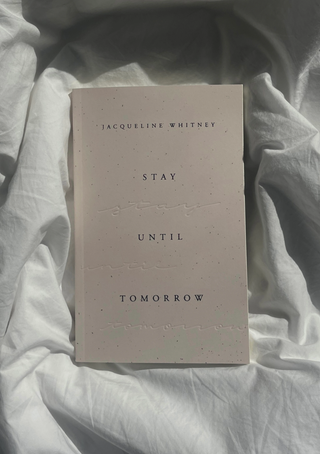 Jacqueline Whitney: Stay Until Tomorrow" book cover lying on the bedsheet.