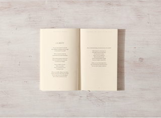 A book with a poem on it resting on a wooden surface, showcasing the beauty of literature and nature.