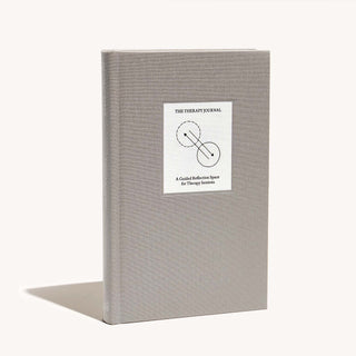 Image of an open book with a white cover displayed on a table.