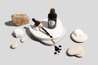 Black tea bottle and rocks on table.