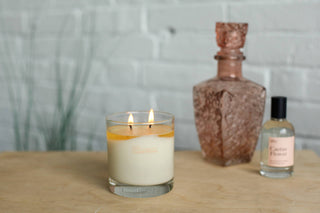 A candle and a bottle of perfume placed side by side, creating a serene and fragrant ambiance.