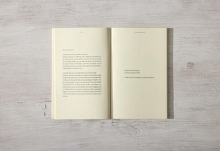 An open book resting on a wooden table.