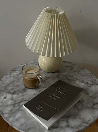 A book placed on a table beside a lamp, creating a cozy reading corner.