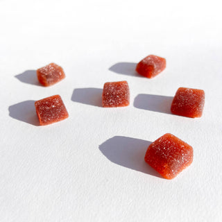 Assorted orange candy pieces on white background.