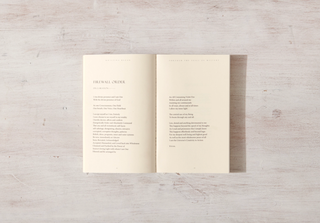 A book with a poem on it resting on a wooden surface.