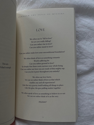 A book open to a page with a poem written on it, showcasing beautiful calligraphy and intricate illustrations.