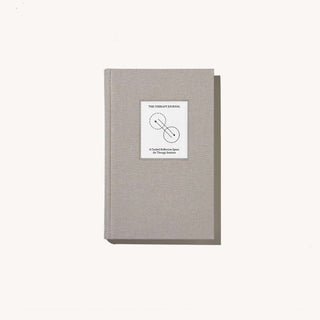 A book with a white cover and a black and white logo, representing simplicity and elegance.