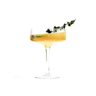 A cocktail glass with a sprig of thyme, adding a touch of freshness and elegance to the drink.