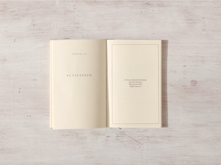 A white-covered book with a white page, open and displaying the word "activation".