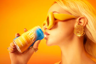 Woman in sunglasses holding a soda can.