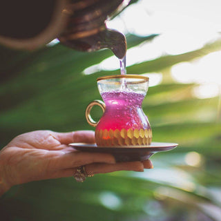 Person holding a cup of purple tea.