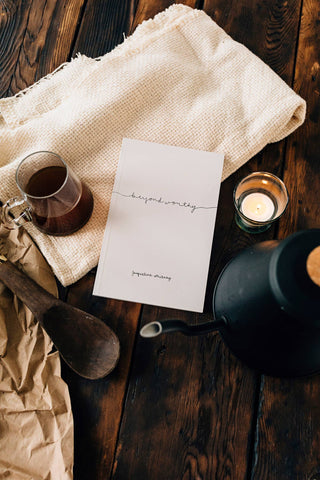 A book, a cup of tea, and a spoon on a wooden table - a cozy scene for a relaxing read and a warm beverage.