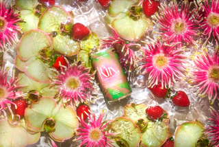 A can of soda surrounded by a vibrant arrangement of flowers and fresh fruit. Refreshing and colorful.
