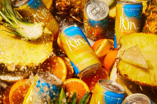 Assorted cans and fruit with water droplets.