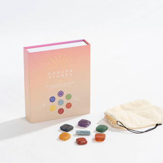 Chakra stones and a book in a pouch, representing spiritual healing and knowledge.