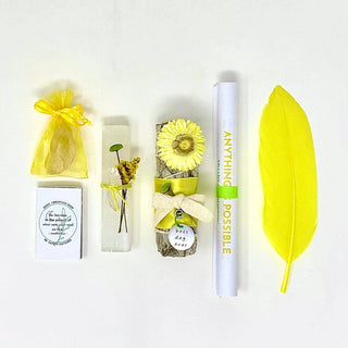 A collection of yellow items including a feather, flower, card, and gift, all in vibrant shades of yellow.