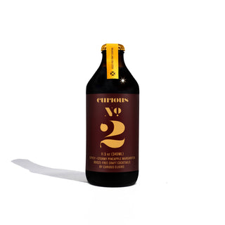 A bottle of Curious No. 2 with a yellow label, perfect for a morning pick-me-up.